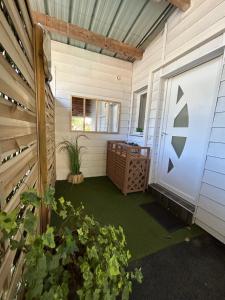 a screened in porch with a door and plants at Maison MAHECO in Gujan-Mestras