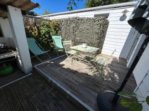 a patio with two chairs and a table on a deck at Maison MAHECO in Gujan-Mestras
