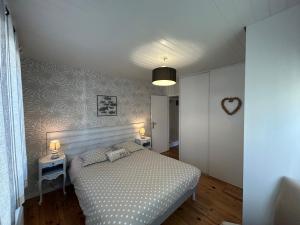 a bedroom with a bed and two tables with lamps at Maison MAHECO in Gujan-Mestras