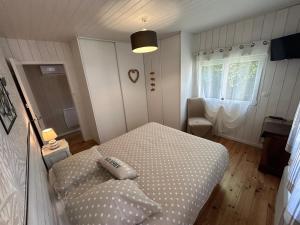 a small bedroom with a bed and a window at Maison MAHECO in Gujan-Mestras