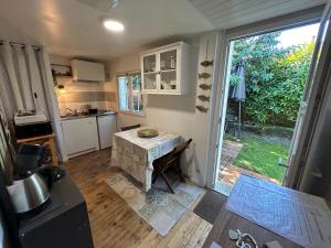 a small kitchen with a table and a large window at Maison MAHECO in Gujan-Mestras