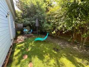 a yard with a green chair and an umbrella at Maison MAHECO in Gujan-Mestras