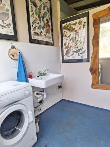 a bathroom with a washing machine and a sink at Domek Wiedźmy in Kaleńsko