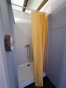 a bathroom with a shower with an orange shower curtain at Domek Wiedźmy in Kaleńsko +23 photos