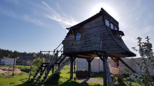 a small wooden house sitting on a tree stump at Domek Wiedźmy in Kaleńsko