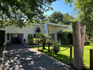 a white house with a fence and a driveway at Maison MAHECO in Gujan-Mestras