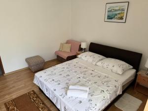 a small bedroom with a bed and a chair at Apartment Teo & Leon in Novi Vinodolski