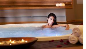 a woman in a jacuzzi tub with candles at Alasia Boutique Hotel in Limassol