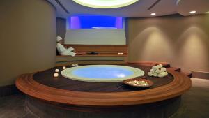 a jacuzzi tub in a room with a man sitting in a bath at Alasia Boutique Hotel in Limassol