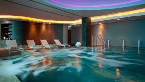 a large swimming pool in a hotel with chairs and a spa at Alasia Boutique Hotel in Limassol