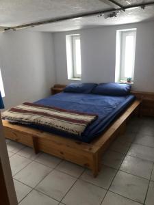 a bed in a room with two windows at Casa Din Deal in Podişu