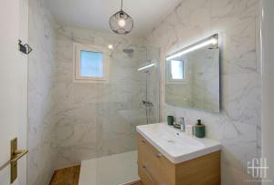 a white bathroom with a sink and a mirror at Plumeria - A 2min de Tours in Tours