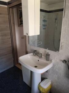 a bathroom with a white sink and a shower at Apartma Ester in Lucija +8 photos