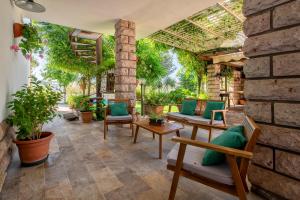 a patio with chairs and tables and a brick wall at Casa vacanza Baddelonga in Sassari