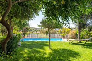a yard with a swimming pool with a bench and trees at Casa vacanza Baddelonga in Sassari