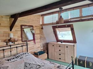 a bedroom with a bed and a mirror at Domek Wiedźmy in Kaleńsko
