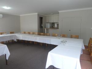 a dining room with white tables and chairs at The Aston Motel Tamworth in Tamworth