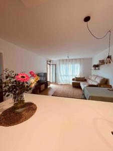 Una sala de estar con un jarrón de flores sobre una mesa. en Apartamento de lujo en Vilanova de arousa, en Villanueva de Arosa