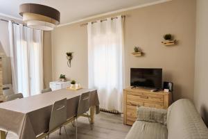 a living room with a dining table and a television at Vista Apartment Bardolino in Bardolino