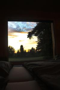 ein Schlafzimmerfenster mit Blick auf den Sonnenuntergang in der Unterkunft Tiny House Waldviertel in Waidhofen an der Thaya