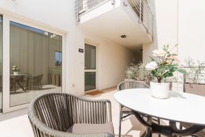 una sala da pranzo con tavolo e sedie bianchi di Domus Lauri Garden Palace II a Umag (Umago)