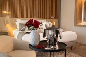 a bedroom with a bed with a vase of flowers on a table at Hôtel Spa Restaurant Villa Castellane by Germain Collection in Gréoux-les-Bains