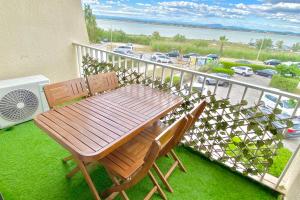a wooden table and two chairs on a balcony at Le Moderna 1 ère ligne Bord de Mer Palavas in Palavas-les-Flots