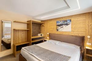 a bedroom with a bed and wooden walls at A Due Passi Rosso in Livigno