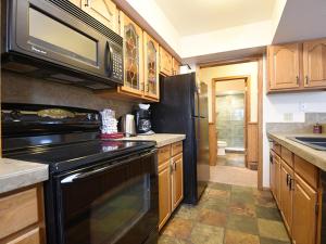 a kitchen with a black stove and a microwave at 61 Jabberwocky Home by Stay Winter Park in Fraser