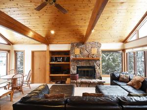 a living room with a couch and a stone fireplace at 61 Jabberwocky Home by Stay Winter Park in Fraser