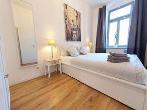 une chambre blanche avec un grand lit avec une fenêtre dans l'établissement 2 room apartment near station Neustadt in Dresden Neustadt, à Dresde