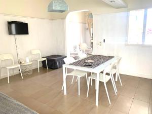 a dining room with a white table and chairs at VIRVIT CASA VACANZE in Porto Cesareo