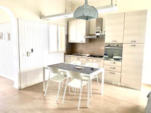 a kitchen with a table and chairs in a room at VIRVIT CASA VACANZE in Porto Cesareo