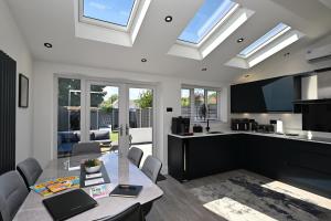 a kitchen and living room with a table and chairs at Super Modern 3 bedroom semi-detached. in Rugby