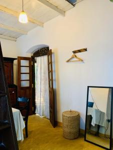 Zimmer mit einem Spiegel, einem Stuhl und einem Fenster in der Unterkunft Heritage Home in Kosgoda