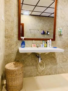 ein Badezimmer mit Waschbecken und Spiegel in der Unterkunft Heritage Home in Kosgoda
