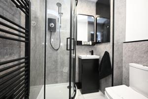 a bathroom with a shower and a toilet and a sink at Super Modern 3 bedroom semi-detached. in Rugby +13 photos