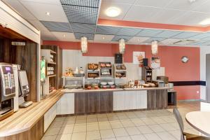 eine große Küche mit Theke in einem Restaurant in der Unterkunft Ace Hotel Montluçon in Saint-Victor + 3 Fotos