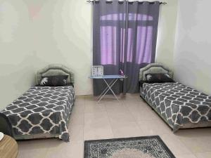 two beds in a room with a purple curtain at Hostel Maral in Mawāliḩ +5 photos
