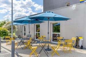 a group of tables and chairs with blue umbrellas at Ace Hotel Montlu&ccedil;on in Saint-Victor