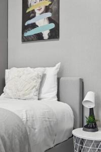 a bedroom with a white bed with a picture on the wall at Standard Triple Room - Luxe Spot - Next to Central - Shared Bathroom in Sydney +36 photos