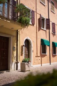 Un edificio con una puerta y una maceta con flores delante. en Vista Apartment Bardolino, en Bardolino