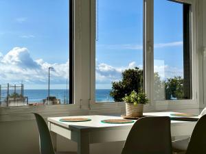 a dining room with a table and a view of the ocean at Apartamento en primera linea con vistas al mar - VistaMar Blanes in Blanes