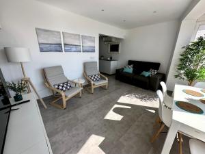 a living room with two chairs and a couch at Apartamento en primera linea con vistas al mar - VistaMar Blanes in Blanes