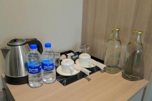 ein Tisch mit Wasserflaschen und einer Kaffeemaschine in der Unterkunft Mount Land in Sultan Bathery