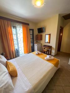 a bedroom with a large bed with towels on it at Pantelidis Rooms in Skala Potamias