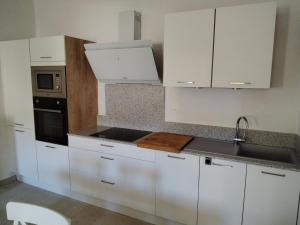 トレイユにあるGites Torreillans - Nid douilletの白いキッチン(白いキャビネット、シンク付) +5枚の写真