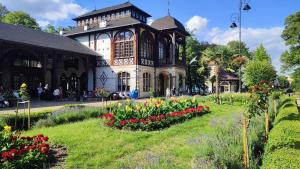 a building with a garden with flowers in front of it at Apartamenty Anka Szczawno Zdrój in Szczawno-Zdrój