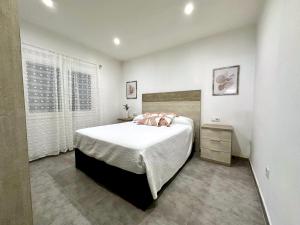 a bedroom with a large bed and a window at Apartamento en primera linea con vistas al mar - VistaMar Blanes in Blanes