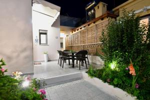 a patio with a table and chairs and plants at Elli's Private House in Ialysos